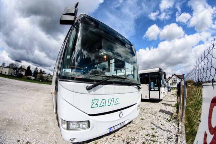 prz&oacute;d białego autokaru z zielonym napisem Żana